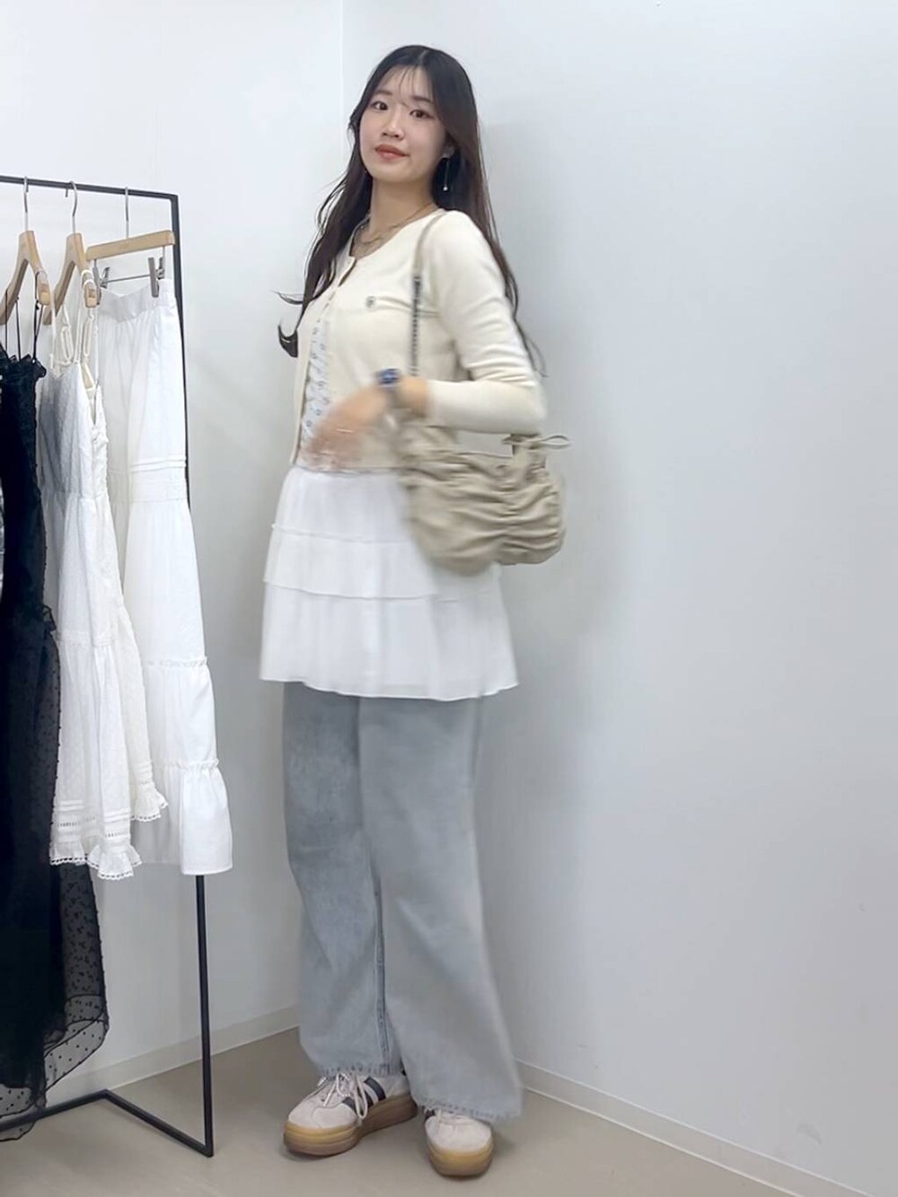 ホワイト系のキャミソール、ブルー系のデニムパンツ、ホワイト系のスカートを着用したレディースの春コーディネートの7枚目の写真