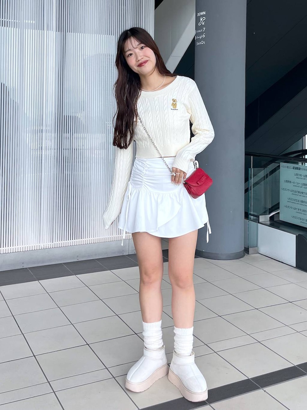 ホワイト系のTシャツ/カットソー、レッド系のショルダーバッグ、ホワイト系のブーツを着用したレディースの冬コーディネートの10枚目の写真