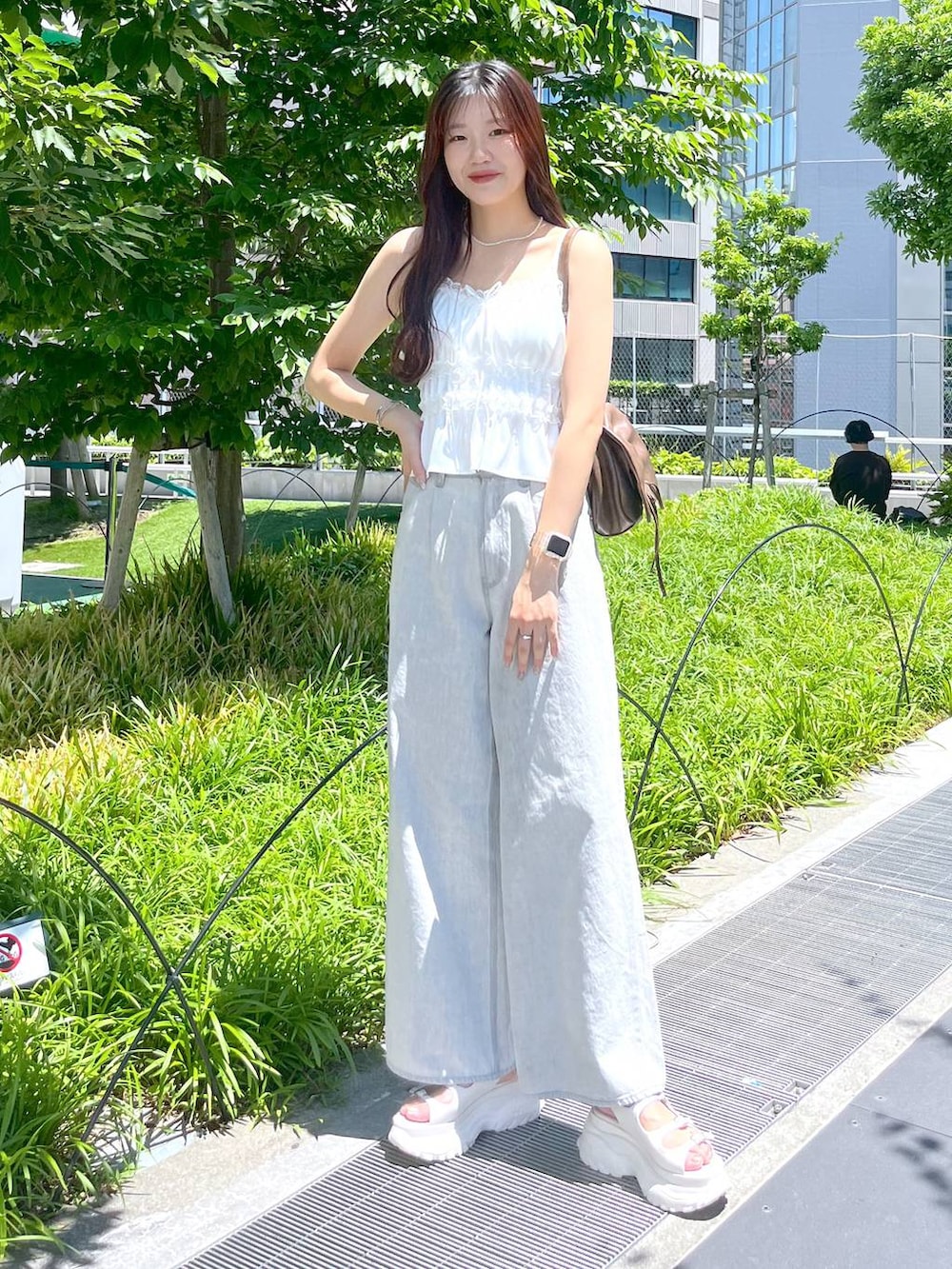 ホワイト系のキャミソール、グレー系のデニムパンツ、ホワイト系のサンダルを着用したレディースの夏コーディネートの7枚目の写真