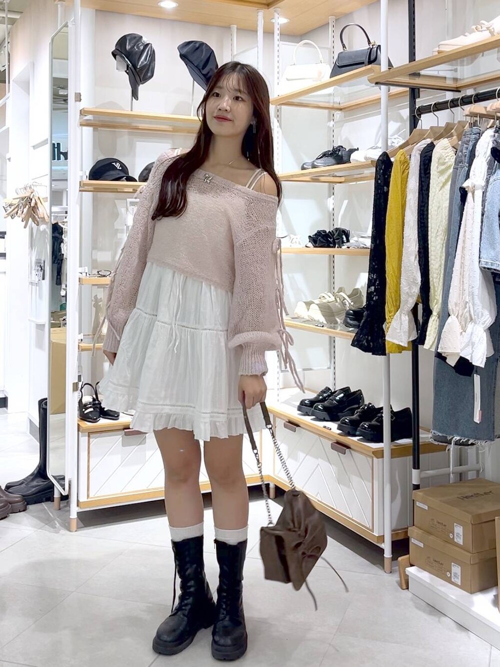 ブラウン系のショルダーバッグ、ピンク系のニット/セーター、ホワイト系のキャミソールを着用したレディースの秋コーディネートの4枚目の写真