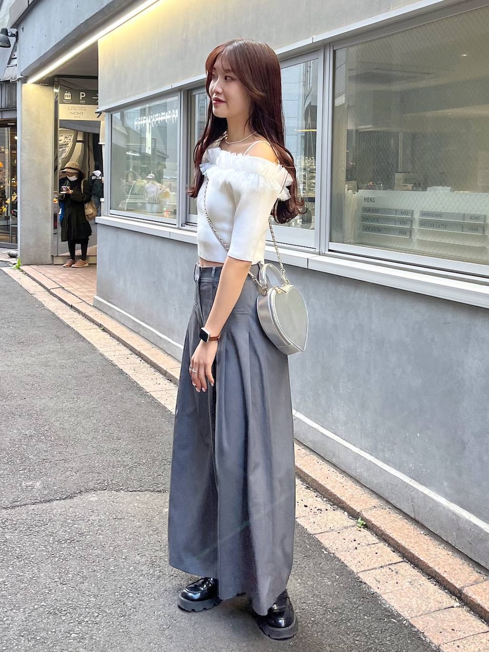 シルバー系のショルダーバッグ、ブラック系のローファー、グレー系のスラックスを着用したレディースの春コーディネートの2枚目の写真