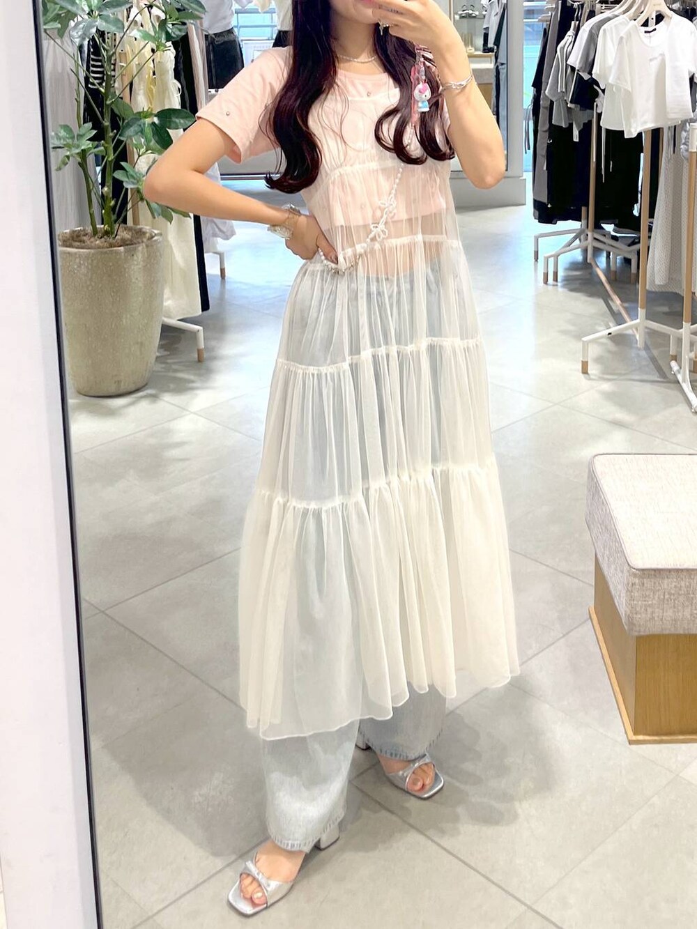 ホワイト系のワンピース、ピンク系のTシャツ/カットソー、シルバー系のサンダルを着用したレディースの春コーディネートの3枚目の写真