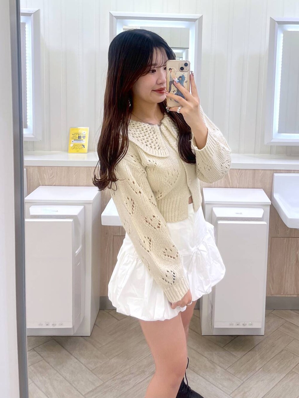 ホワイト系のキャミソール、ホワイト系のスカート、ホワイト系のカーディガン/ボレロを着用したレディースの冬コーディネートの3枚目の写真