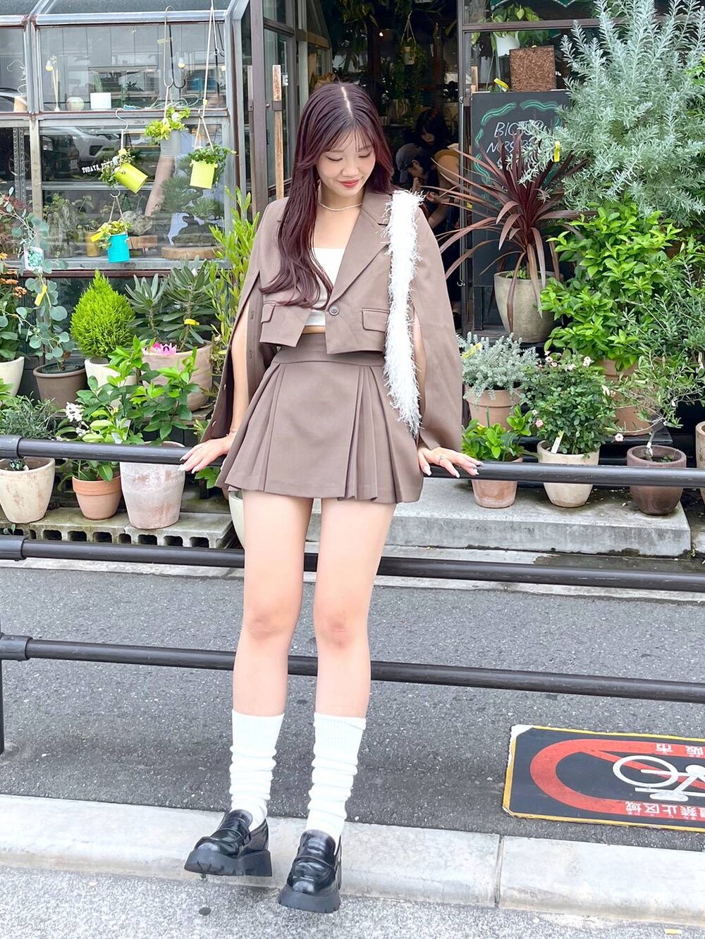 ブラウン系のテーラードジャケット、ブラウン系のスカート、ホワイト系のキャミソールを着用したレディースの夏コーディネートの5枚目の写真