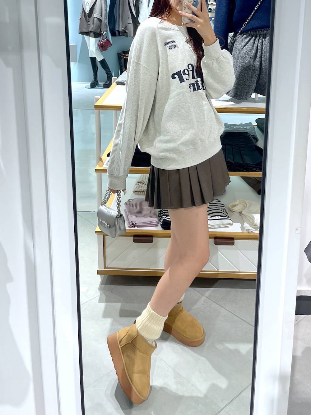 ホワイト系のTシャツ/カットソー、ブラウン系のスカート、ベージュ系のブーツを着用したレディースの冬コーディネートの10枚目の写真