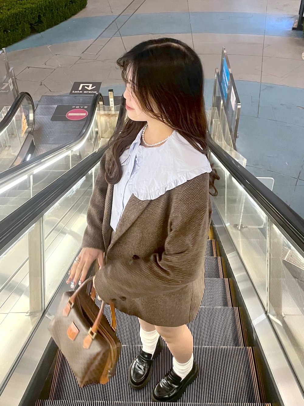 ホワイト系のTシャツ/カットソー、ブラウン系のテーラードジャケット、ブルー系のシャツ/ブラウスを着用したレディースの春コーディネートの3枚目の写真