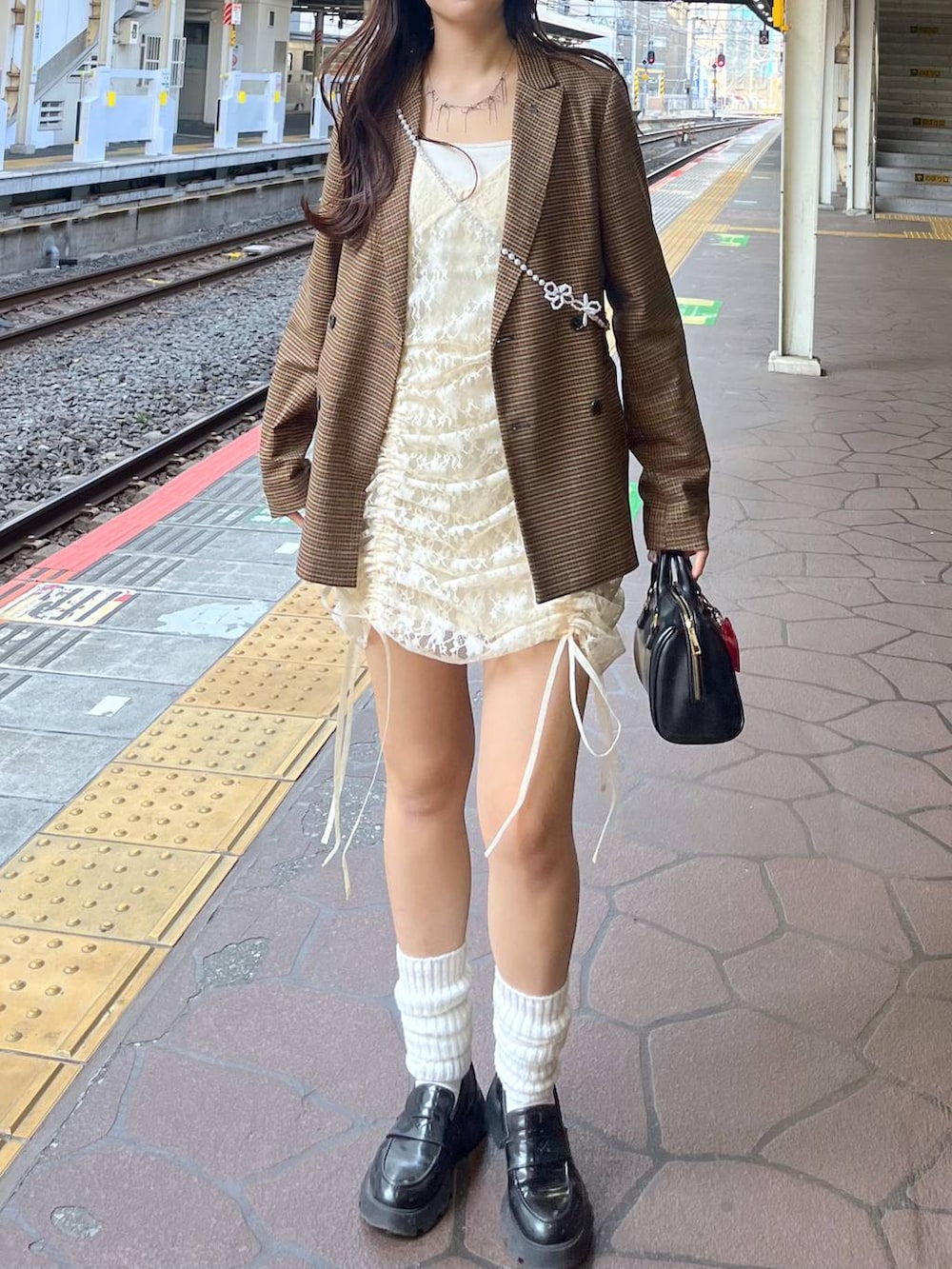 ホワイト系のキャミソール、ベージュ系のワンピース、ブラック系のローファーを着用したレディースの春コーディネートの2枚目の写真