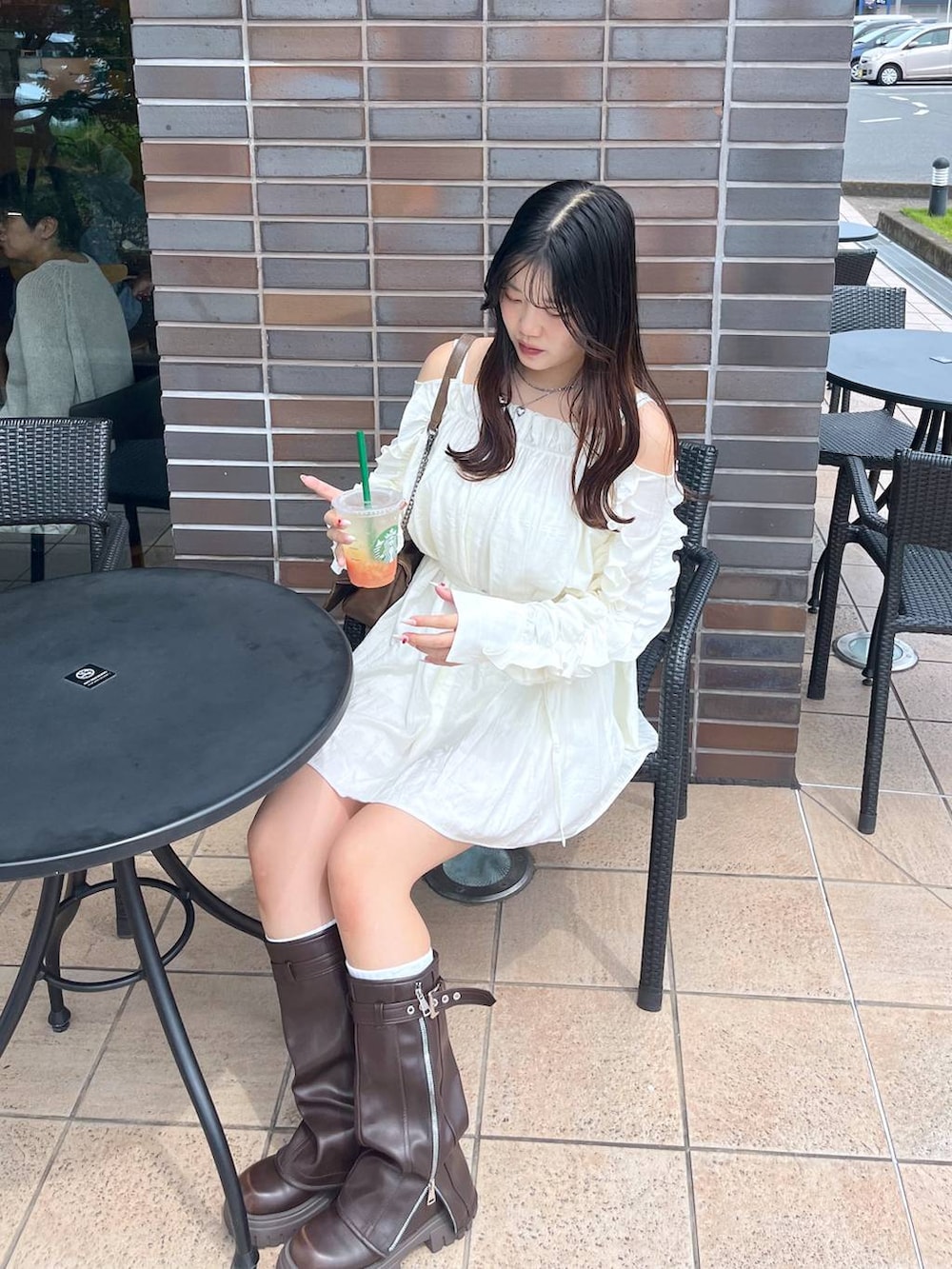 ブラウン系のショルダーバッグ、ブラウン系のブーツ、ホワイト系のキャミソールを着用したレディースの夏コーディネートの4枚目の写真