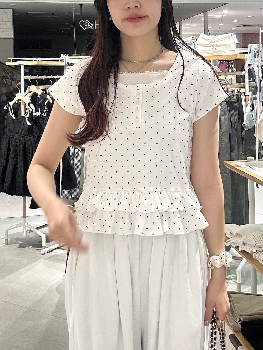ホワイト系のパンプス、ホワイト系のチューブトップ、ブラック系のショルダーバッグを着用したレディースの春コーディネートの7枚目の写真