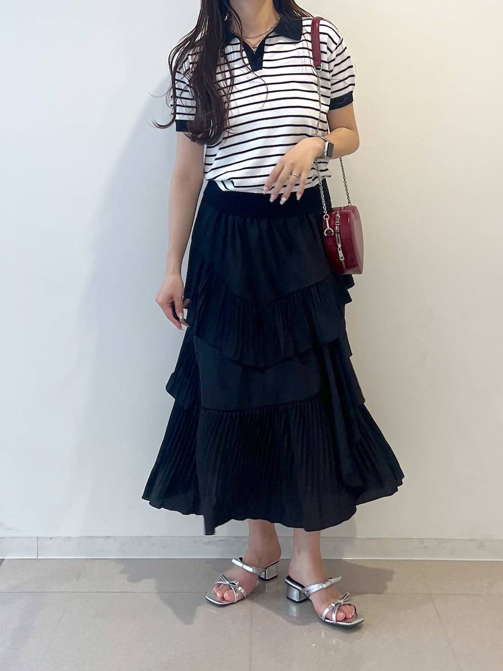 ホワイト系のキャミソール、ブラック系のスカート、シルバー系のサンダルを着用したレディースの春コーディネートの9枚目の写真