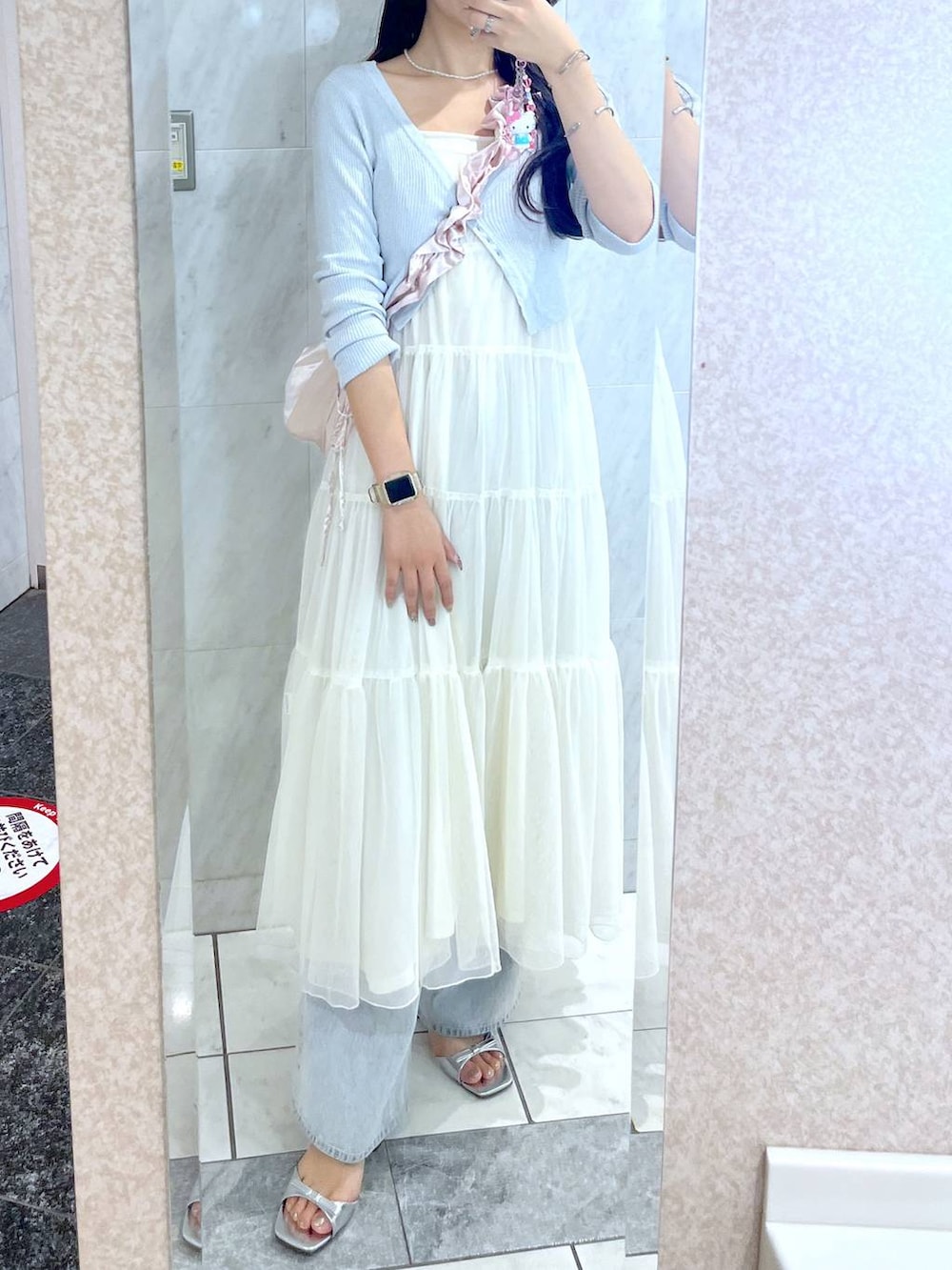 ピンク系のショルダーバッグ、ホワイト系のキャミソール、ブルー系のデニムパンツを着用したレディースの夏コーディネートの3枚目の写真