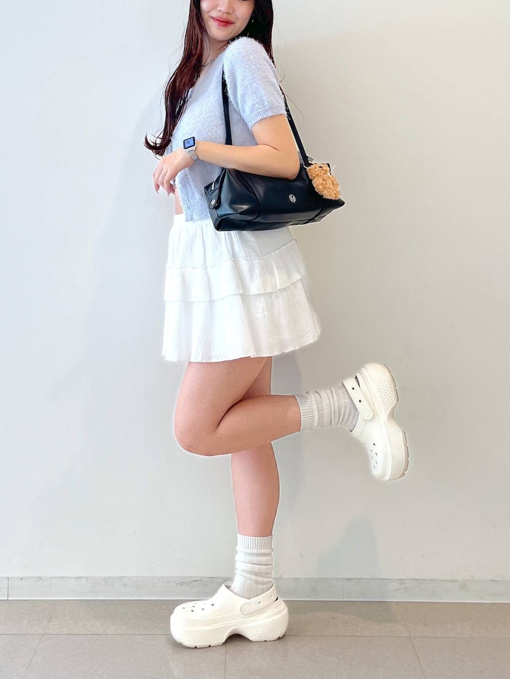 ホワイト系のスカート、ブラック系のボストンバッグ、ホワイト系のキャミソールを着用したレディースの春コーディネートの7枚目の写真
