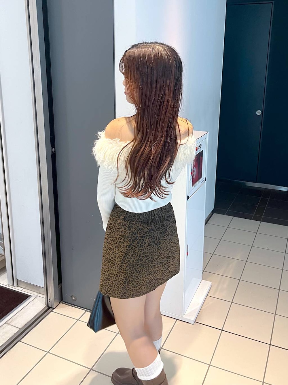 ブラウン系のブーツ、その他のスカート、ホワイト系のキャミソールを着用したレディースの秋コーディネートの6枚目の写真