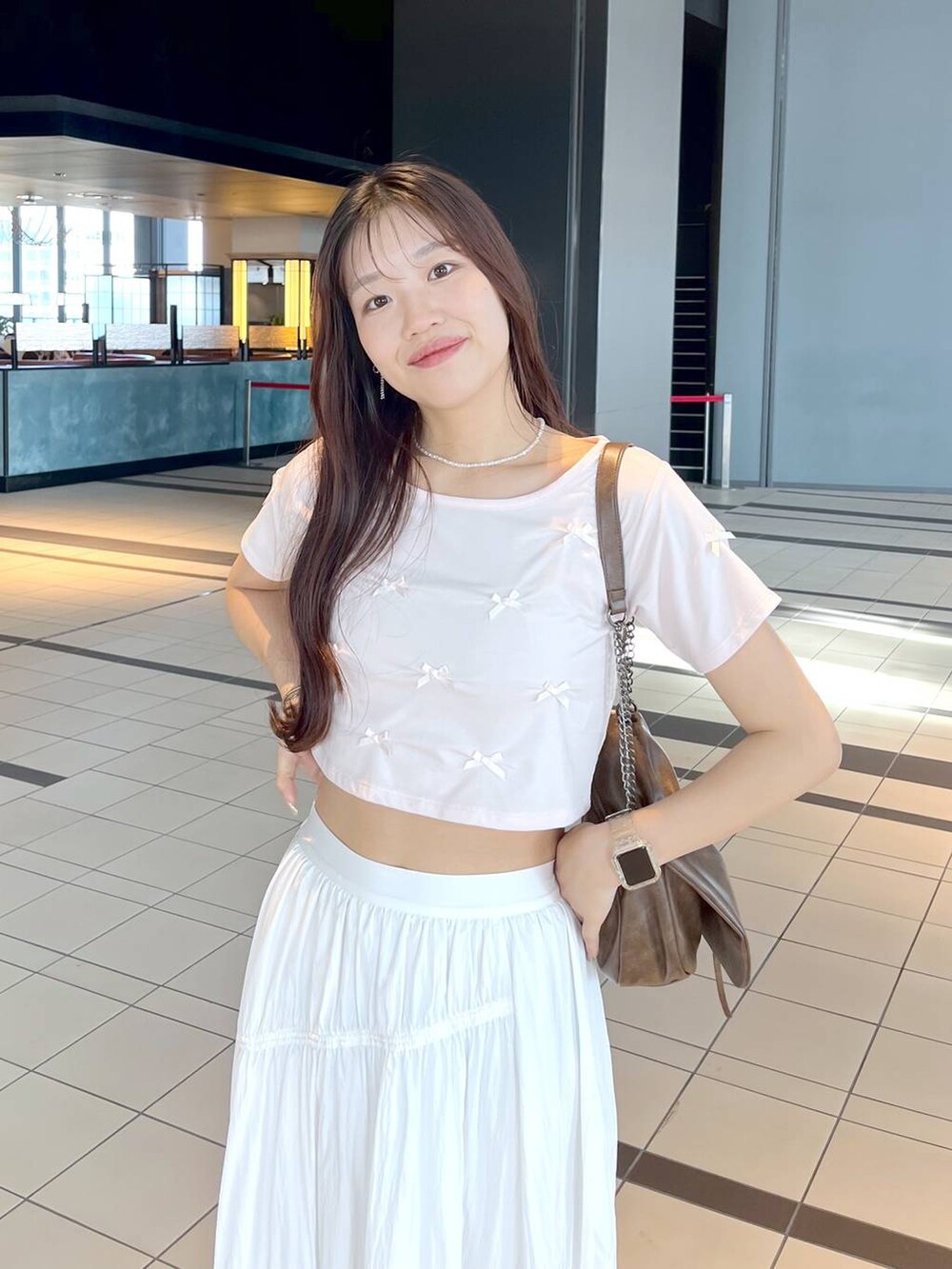 ピンク系のTシャツ/カットソー、ホワイト系のキャミソール、ブラウン系のショルダーバッグを着用したレディースの夏コーディネートの6枚目の写真
