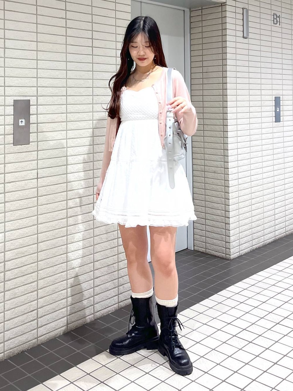 ホワイト系のキャミソール、ピンク系のカーディガン/ボレロ、ブラック系のブーツを着用したレディースの春コーディネートの5枚目の写真