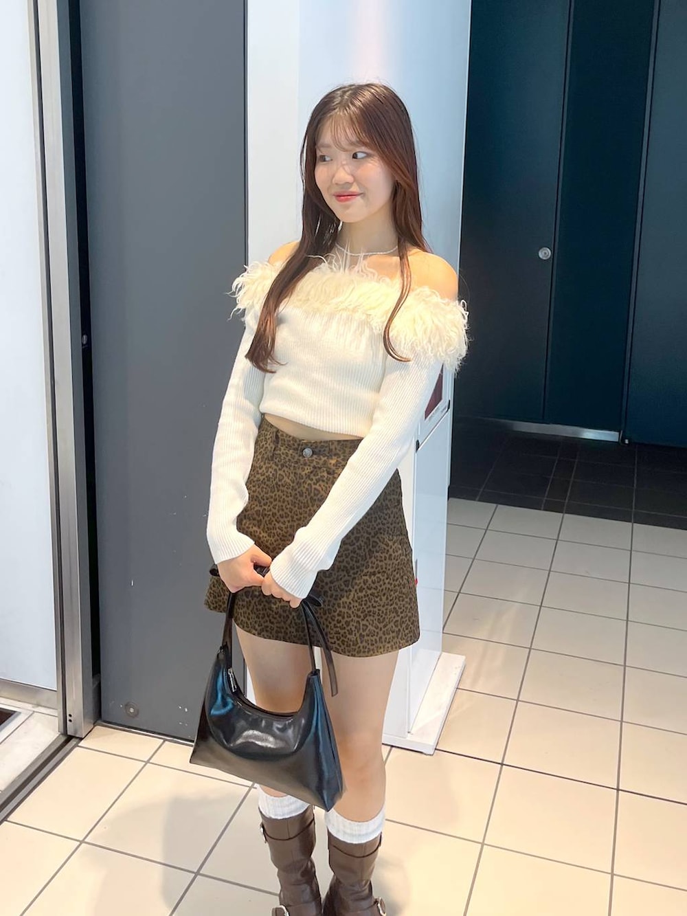 ブラウン系のブーツ、その他のスカート、ホワイト系のキャミソールを着用したレディースの秋コーディネートの7枚目の写真