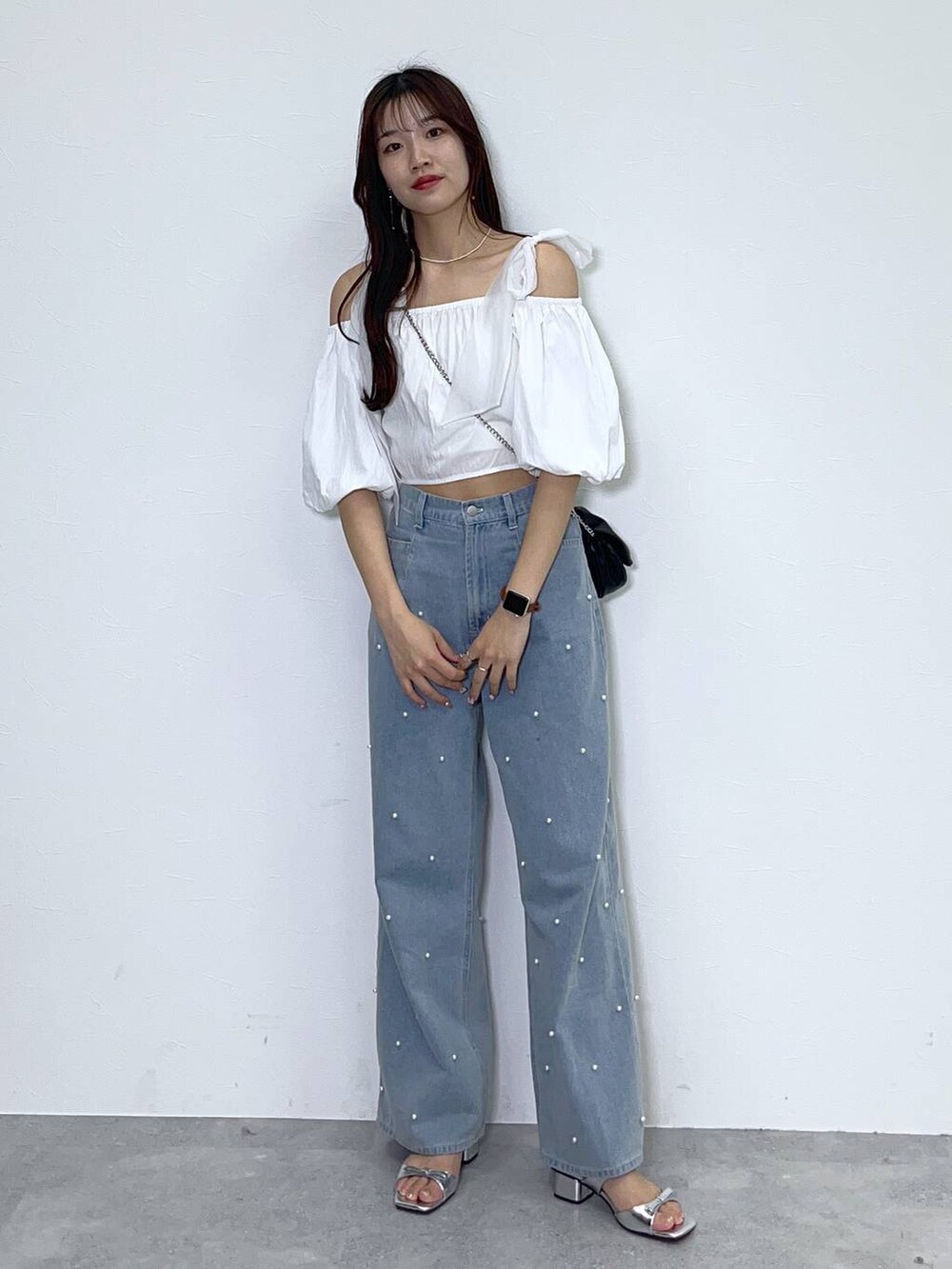 ブラック系のショルダーバッグ、ホワイト系のキャミソール、ブルー系のデニムパンツを着用したレディースの春コーディネートの8枚目の写真