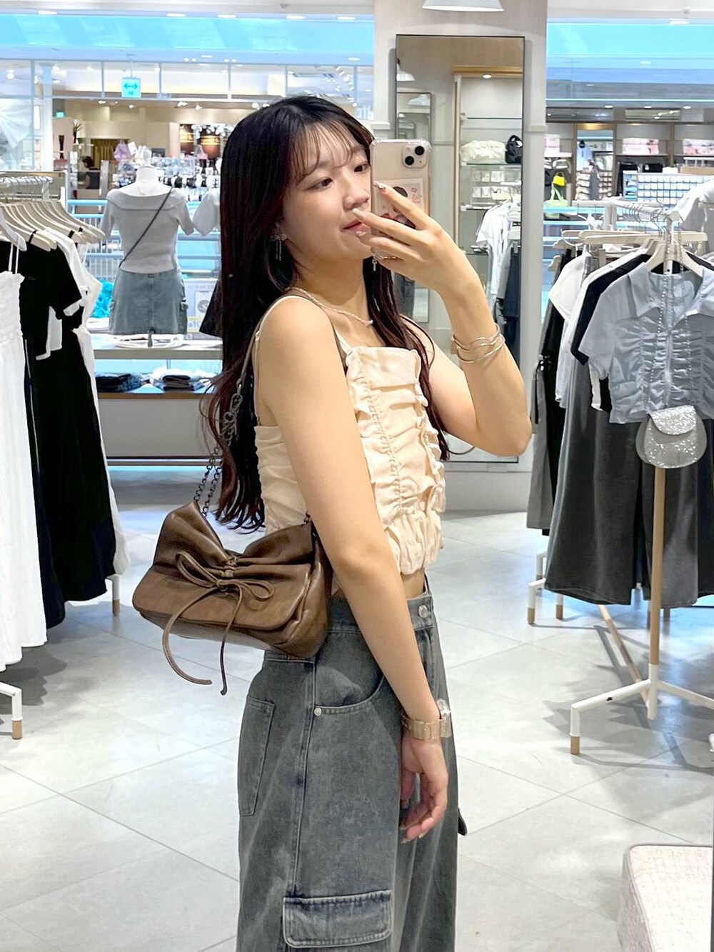 シルバー系のサンダル、ホワイト系のキャミソール、ブルー系のデニムパンツを着用したレディースの夏コーディネートの5枚目の写真