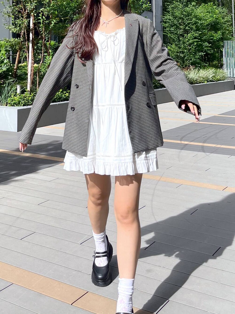 ホワイト系のキャミソール、ホワイト系のワンピース、ブラック系のスニーカーを着用したレディースの秋コーディネートの5枚目の写真