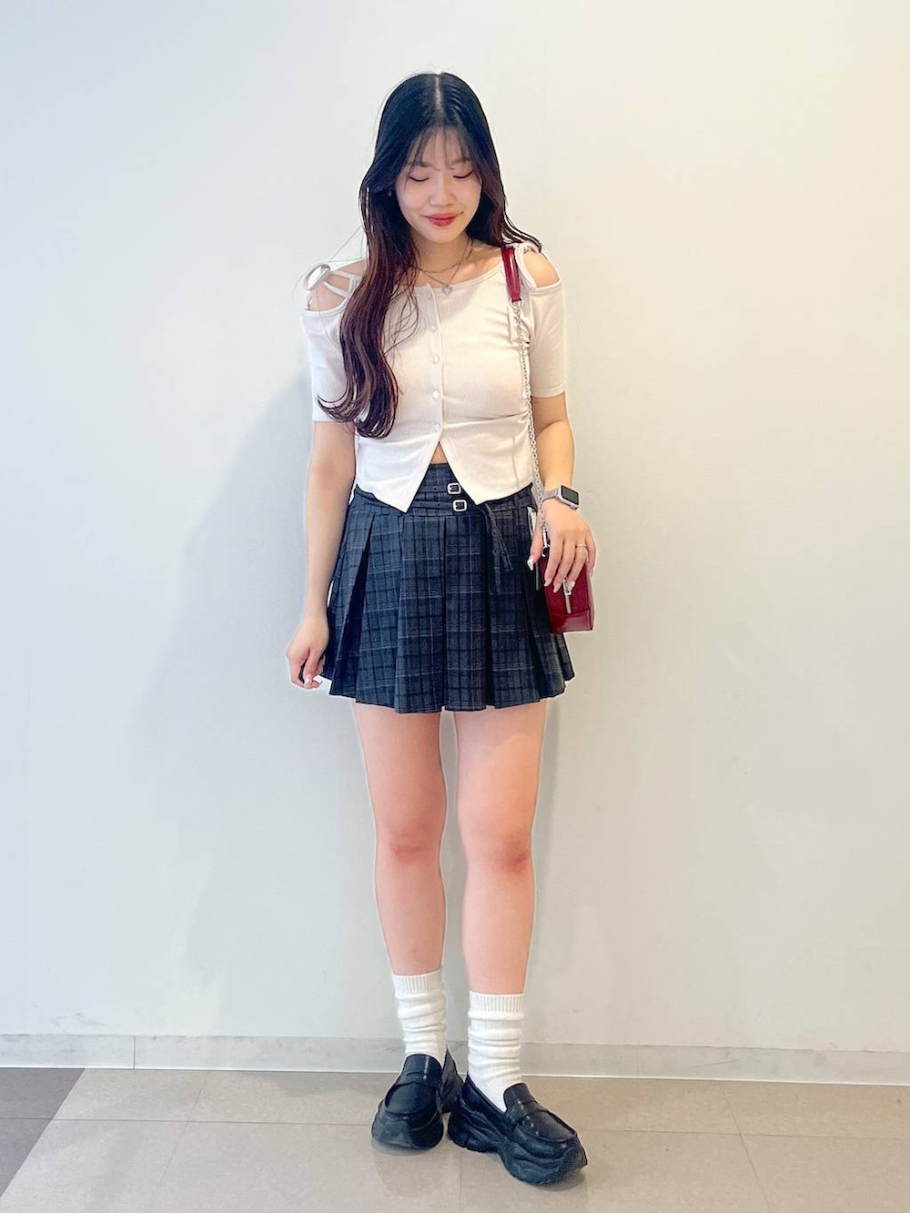 ブラック系のローファー、グレー系のスカート、レッド系のショルダーバッグを着用したレディースの春コーディネートの4枚目の写真