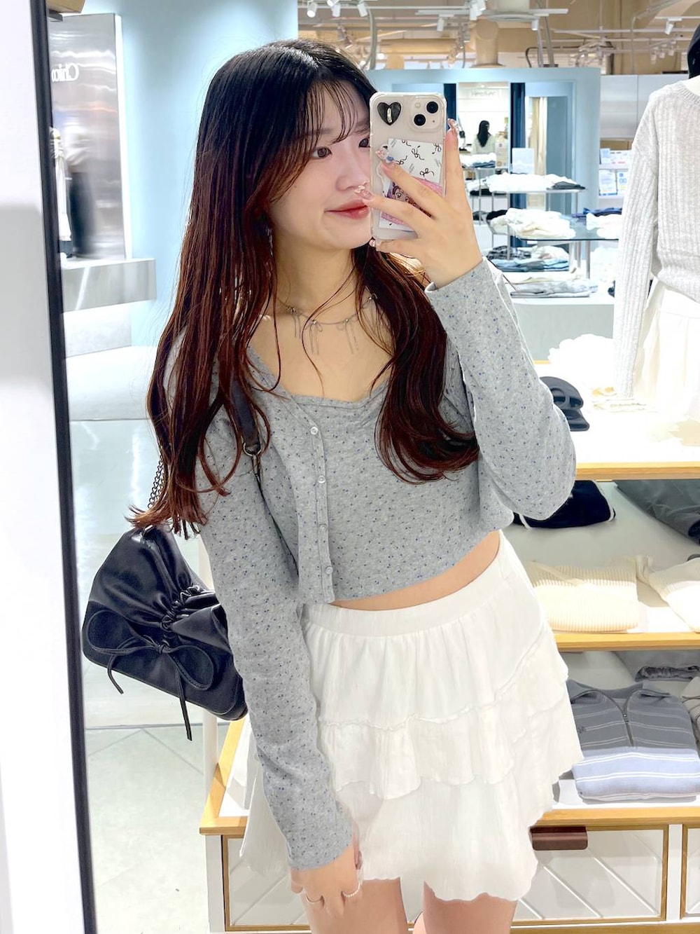 ブラウン系のショルダーバッグ、ホワイト系のキャミソール、ブラック系のブーツを着用したレディースの春コーディネートの4枚目の写真