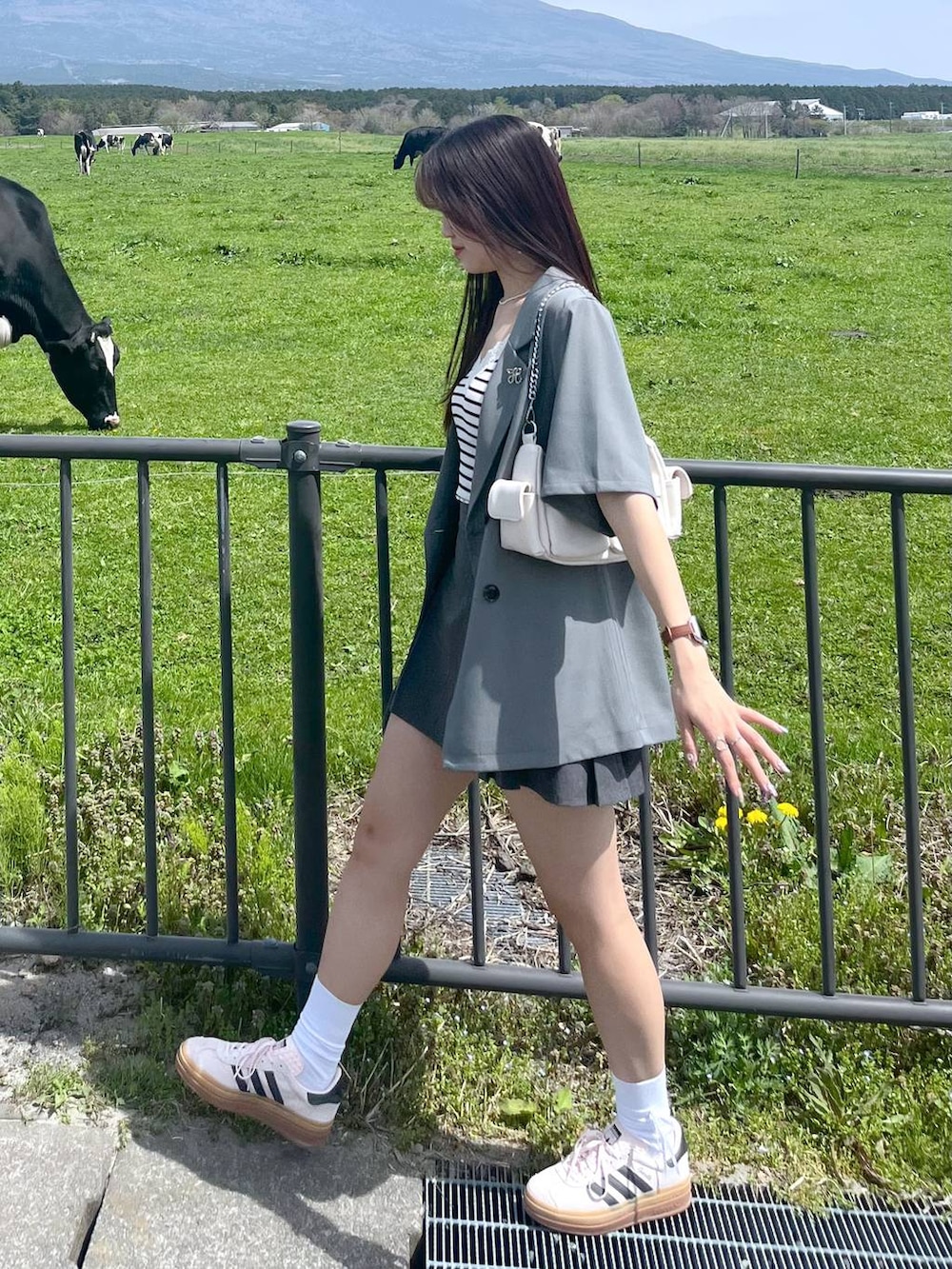 ホワイト系のショルダーバッグ、グレー系のスカート、グレー系のテーラードジャケットを着用したレディースの春コーディネートの3枚目の写真