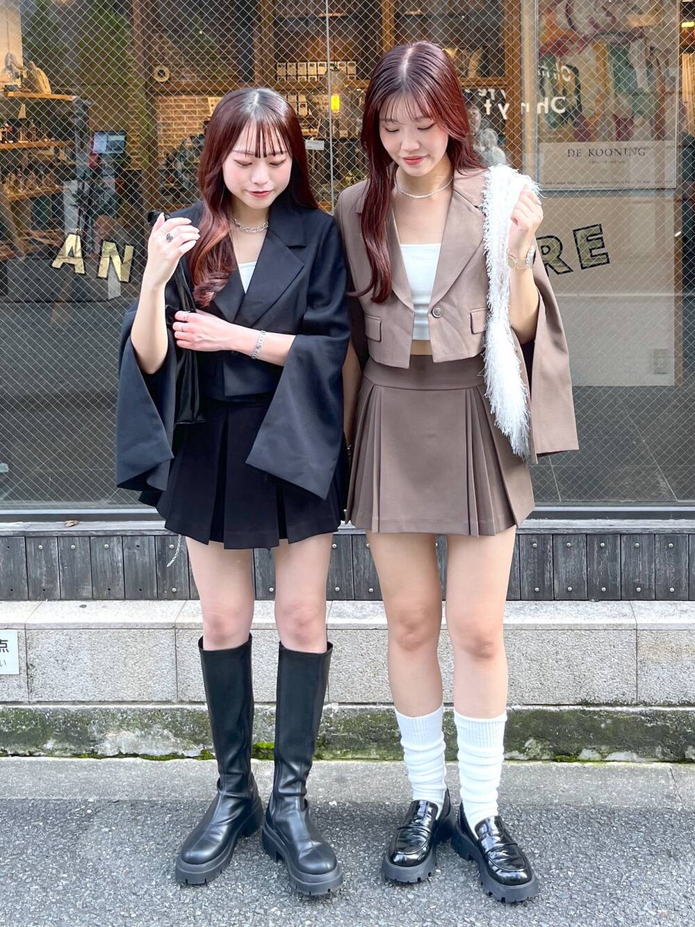 ブラック系のテーラードジャケット、ブラウン系のテーラードジャケット、ブラウン系のスカートを着用したレディースの冬コーディネートの4枚目の写真