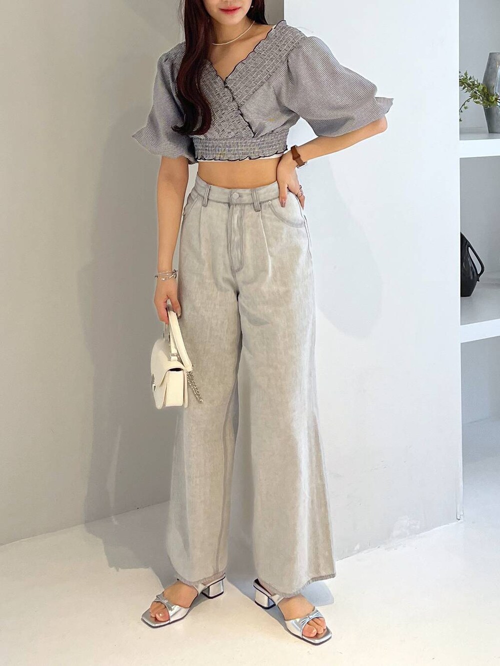 シルバー系のサンダル、ホワイト系のキャミソール、グレー系のデニムパンツを着用したレディースの夏コーディネートの5枚目の写真