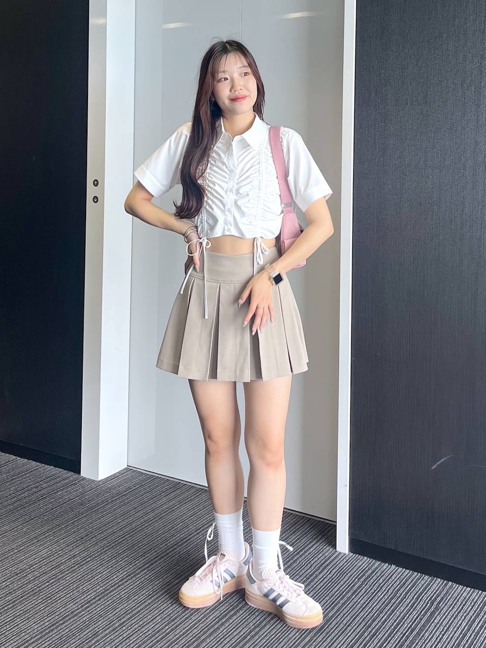 ピンク系のショルダーバッグ、ホワイト系のキャミソール、ベージュ系のスカートを着用したレディースの夏コーディネートの6枚目の写真