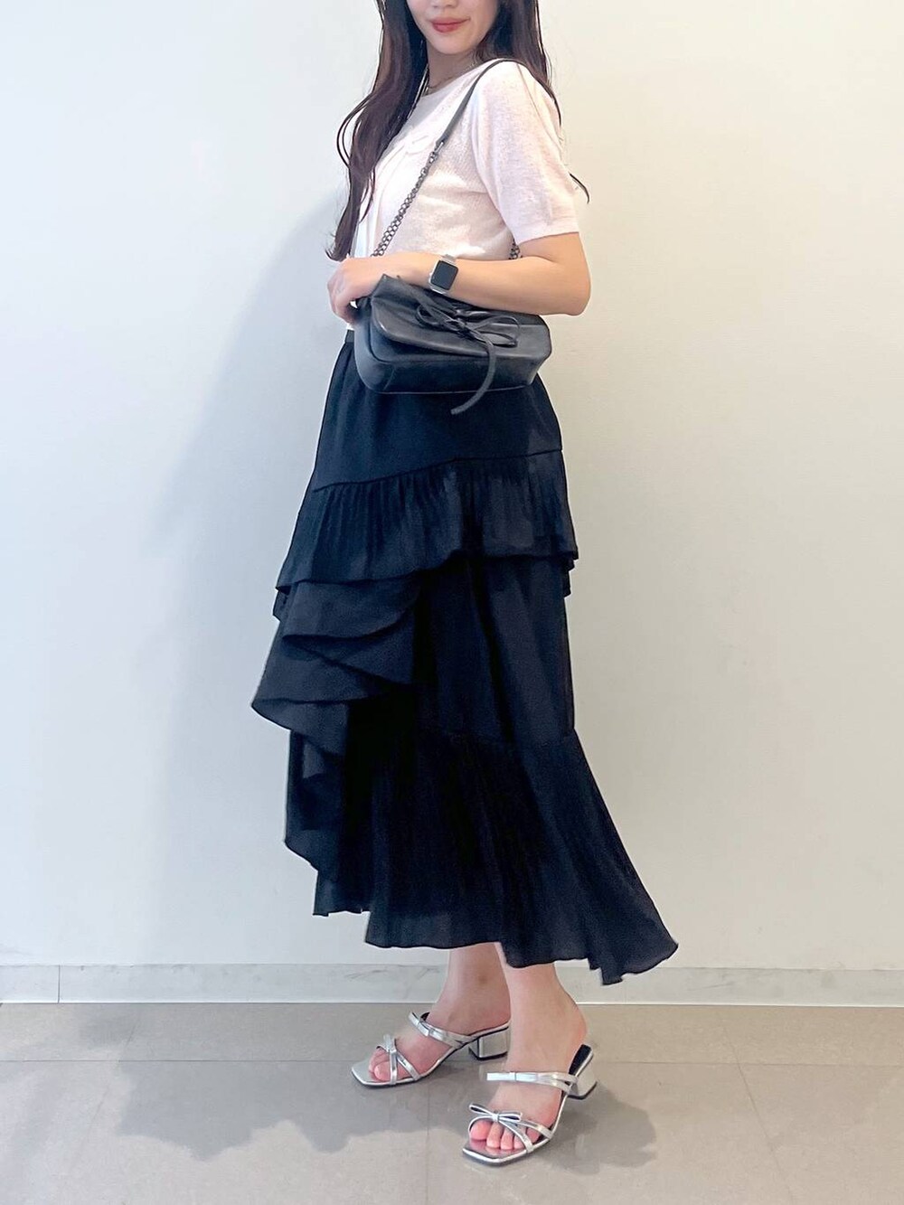 グレー系のショルダーバッグ、ホワイト系のキャミソール、ブラック系のスカートを着用したレディースの春コーディネートの7枚目の写真