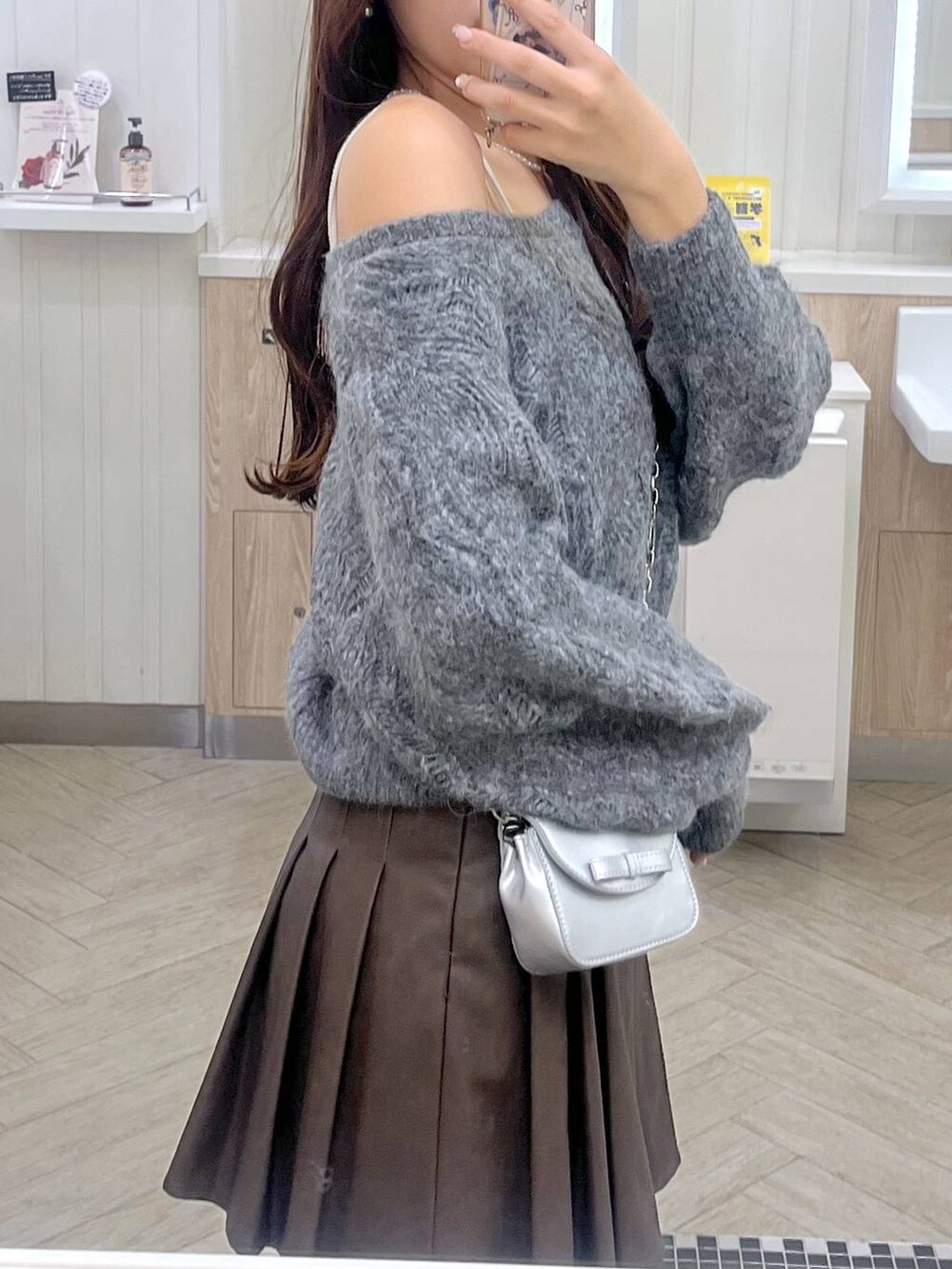 ブラウン系のスカート、ホワイト系のキャミソール、シルバー系のショルダーバッグを着用したレディースの秋コーディネートの6枚目の写真