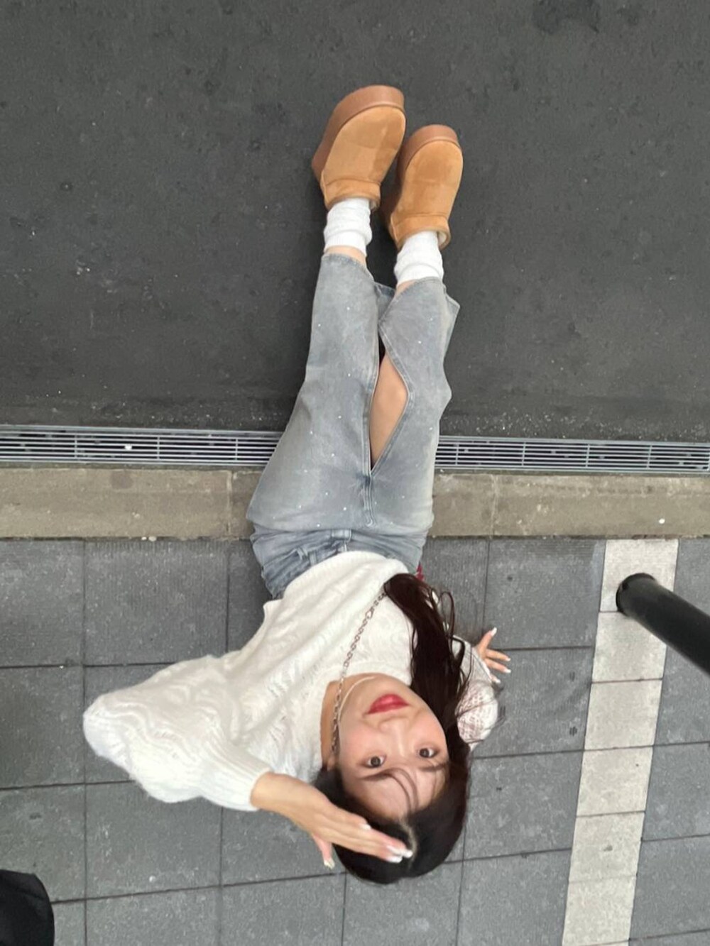 ブルー系のデニムスカート、ホワイト系のキャミソール、レッド系のショルダーバッグを着用したレディースの秋コーディネートの2枚目の写真