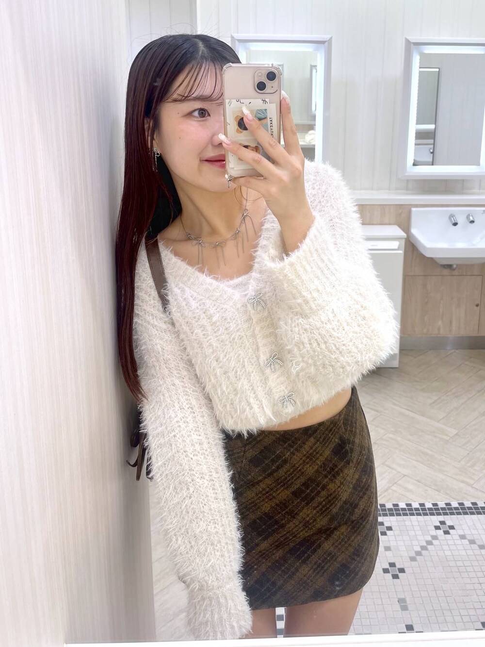 ブラウン系のショルダーバッグ、ホワイト系のブーツ、ホワイト系のキャミソールを着用したレディースの秋コーディネートの2枚目の写真