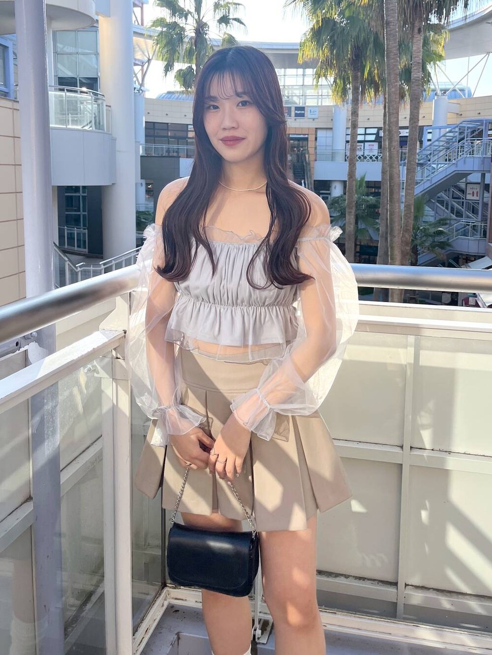 ブラック系のショルダーバッグ、グレー系のシャツ/ブラウス、ホワイト系のキャミソールを着用したレディースの春コーディネートの5枚目の写真