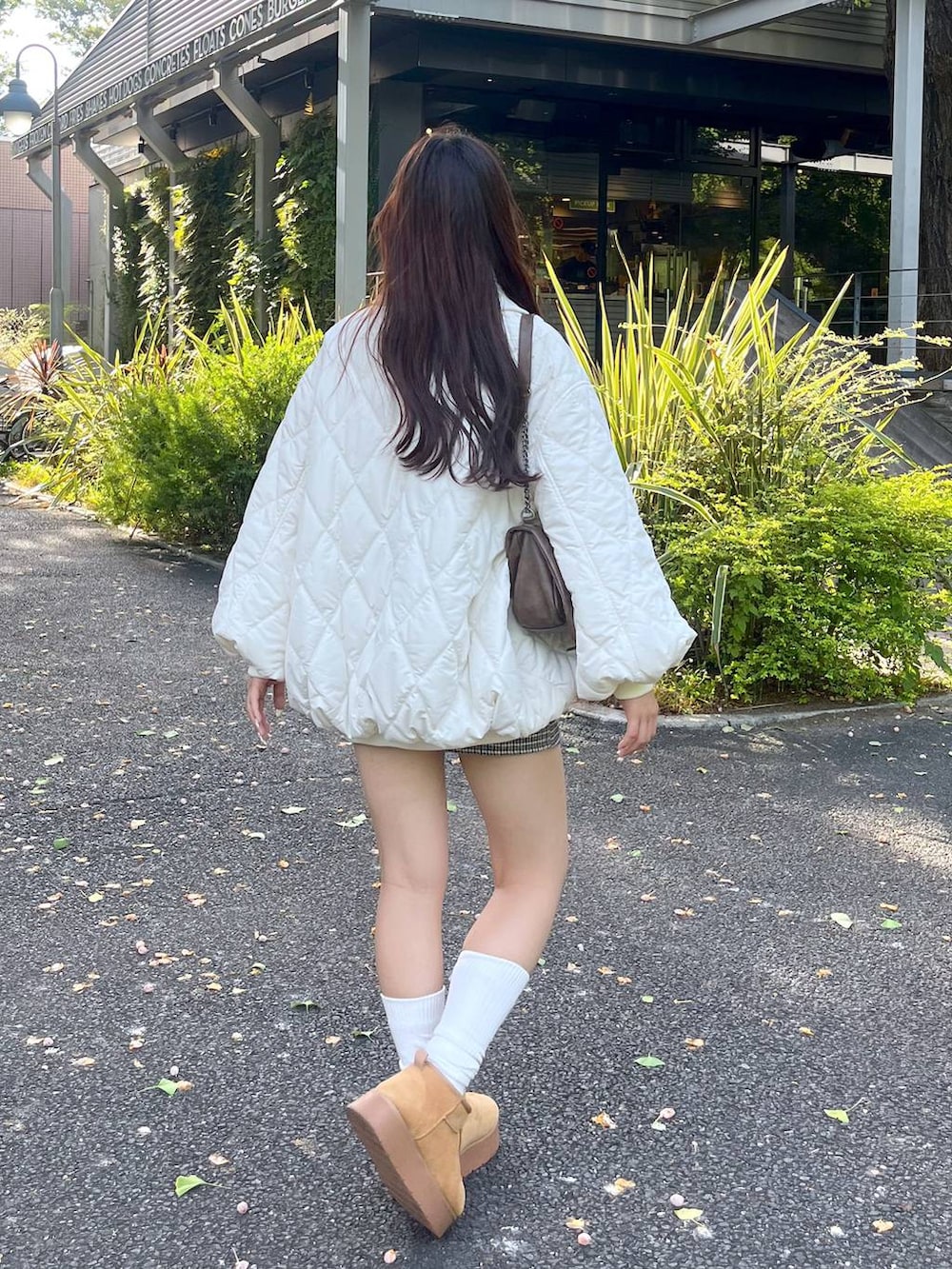 ブラウン系のショルダーバッグ、ホワイト系のTシャツ/カットソー、ベージュ系のブーツを着用したレディースの秋コーディネートの3枚目の写真