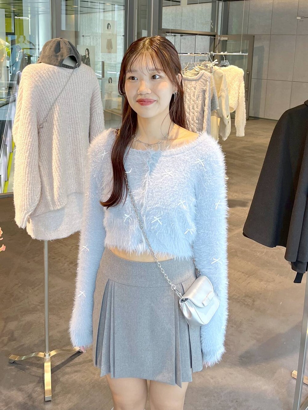 グレー系のスカート、ホワイト系のブーツ、ホワイト系のTシャツ/カットソーを着用したレディースの秋コーディネートの2枚目の写真