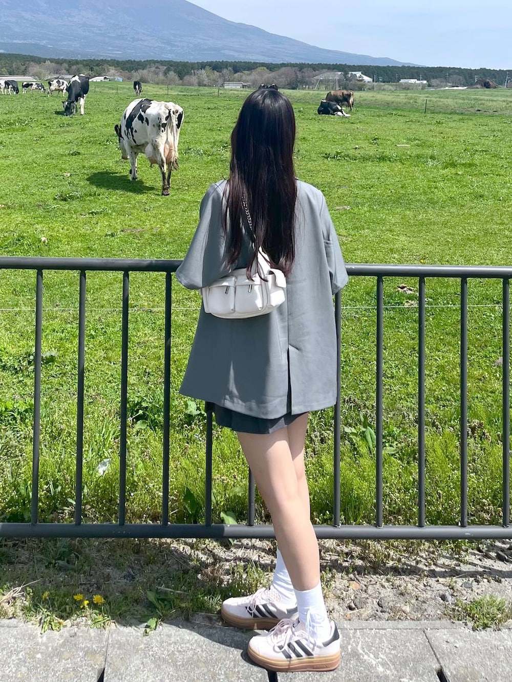 ホワイト系のショルダーバッグ、グレー系のスカート、グレー系のテーラードジャケットを着用したレディースの春コーディネートの4枚目の写真