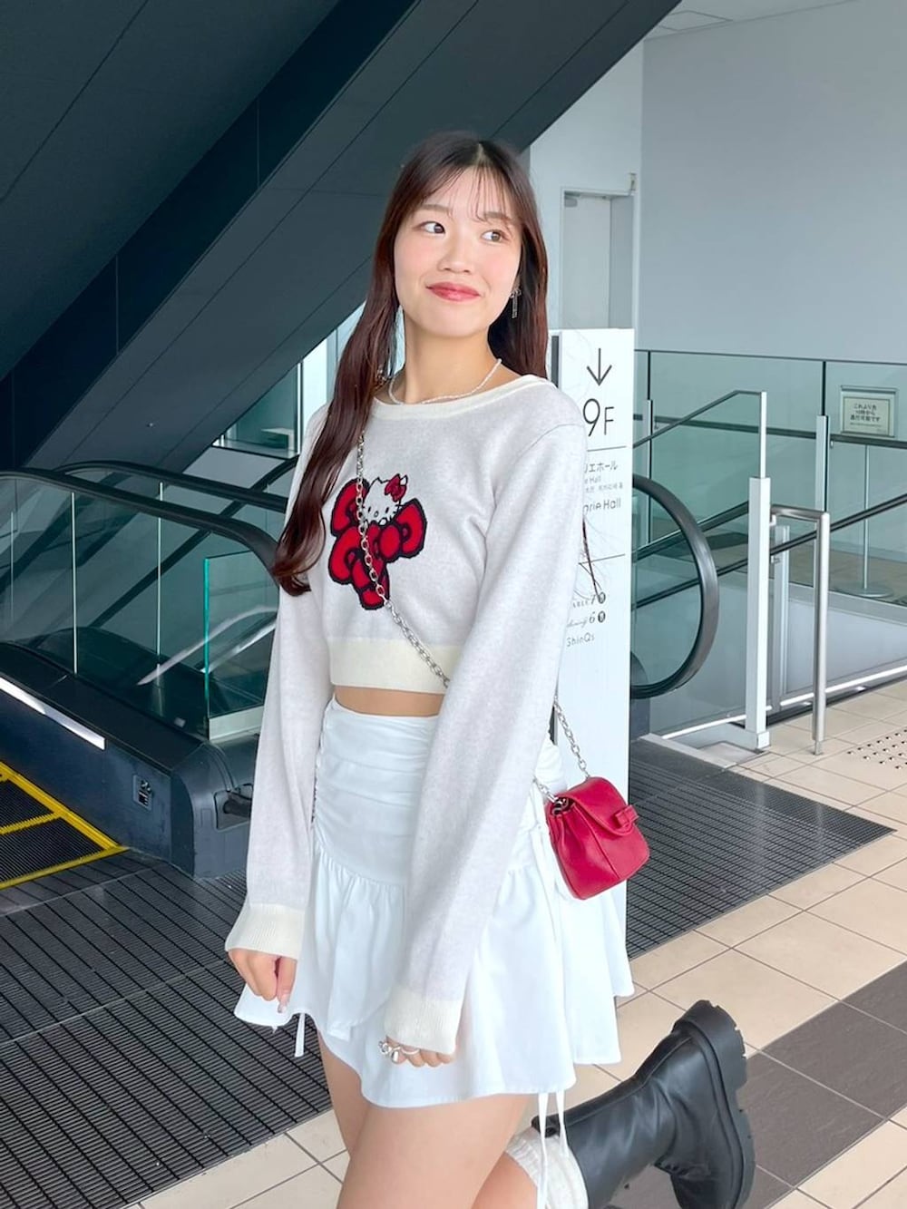 ホワイト系のTシャツ/カットソー、レッド系のショルダーバッグ、ブラック系のブーツを着用したレディースの秋コーディネートの6枚目の写真