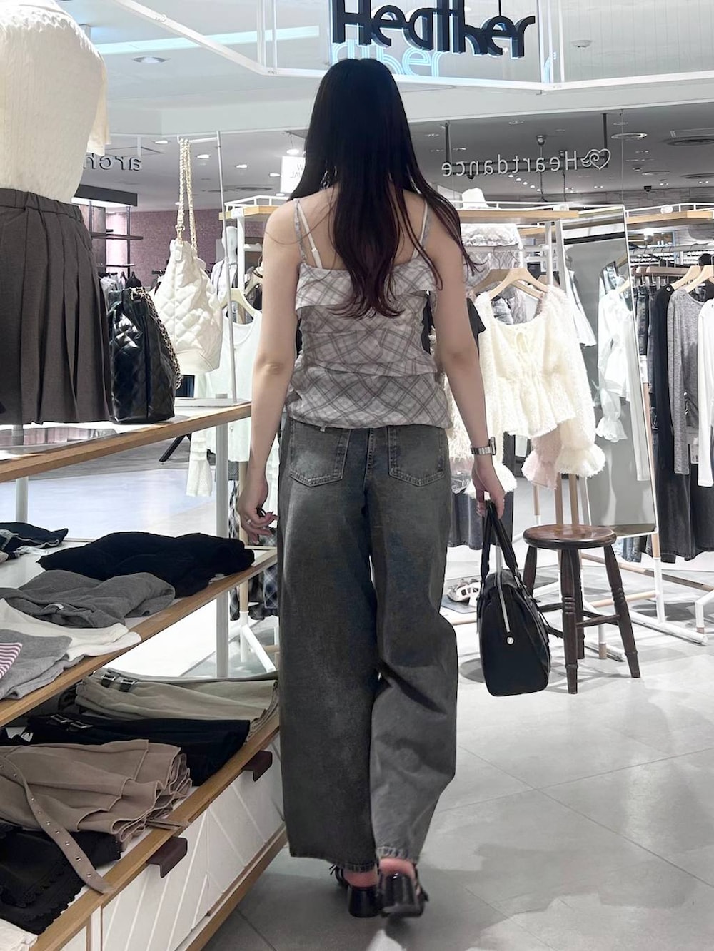ホワイト系のキャミソール、ブルー系のデニムパンツ、ブラック系のボストンバッグを着用したレディースの春コーディネートの3枚目の写真