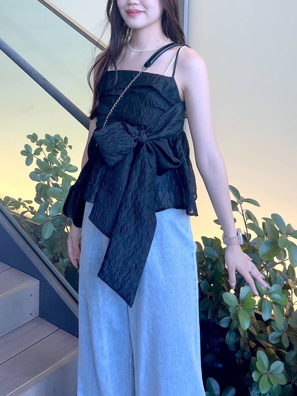 シルバー系のサンダル、ブラック系のショルダーバッグ、ホワイト系のキャミソールを着用したレディースの夏コーディネートの7枚目の写真