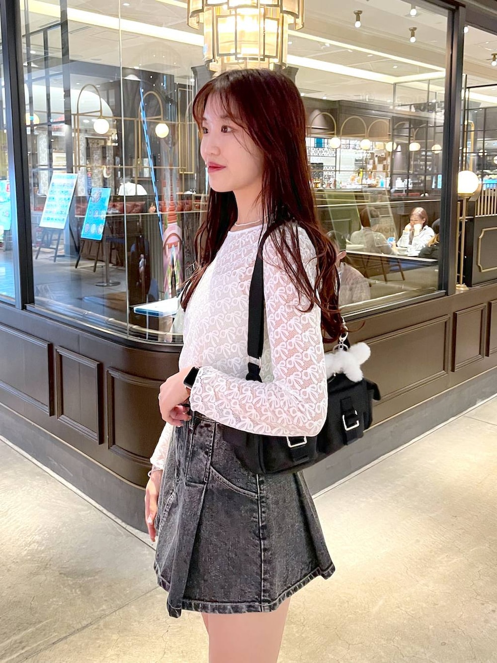 ブラック系のショルダーバッグ、ブラック系のローファー、ブラック系のデニムスカートを着用したレディースの春コーディネートの4枚目の写真