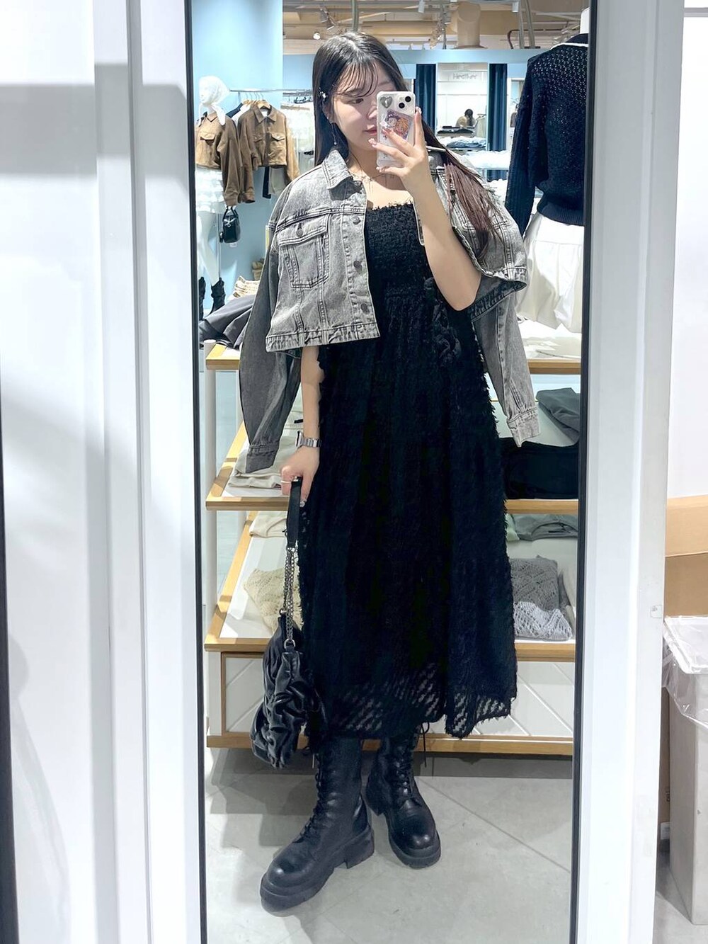 ホワイト系のキャミソール、ブラック系のショルダーバッグ、ブラック系のブーツを着用したレディースの春コーディネートの2枚目の写真