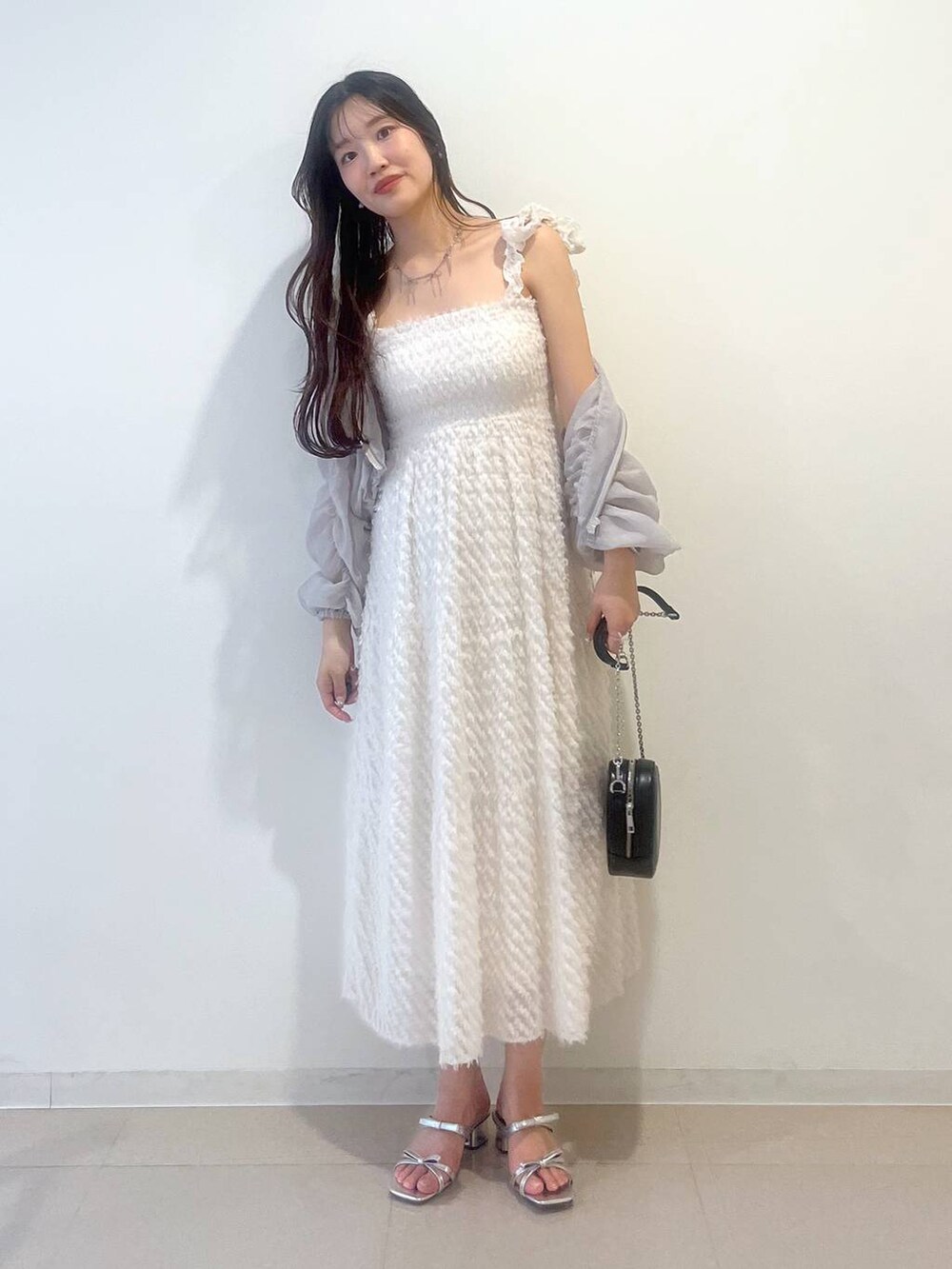 シルバー系のサンダル、ホワイト系のワンピース、グレー系のブルゾンを着用したレディースの春コーディネートの10枚目の写真