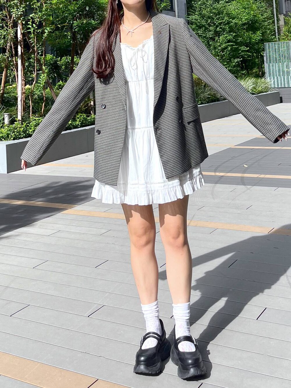 ホワイト系のキャミソール、ホワイト系のワンピース、ブラック系のスニーカーを着用したレディースの秋コーディネートの6枚目の写真