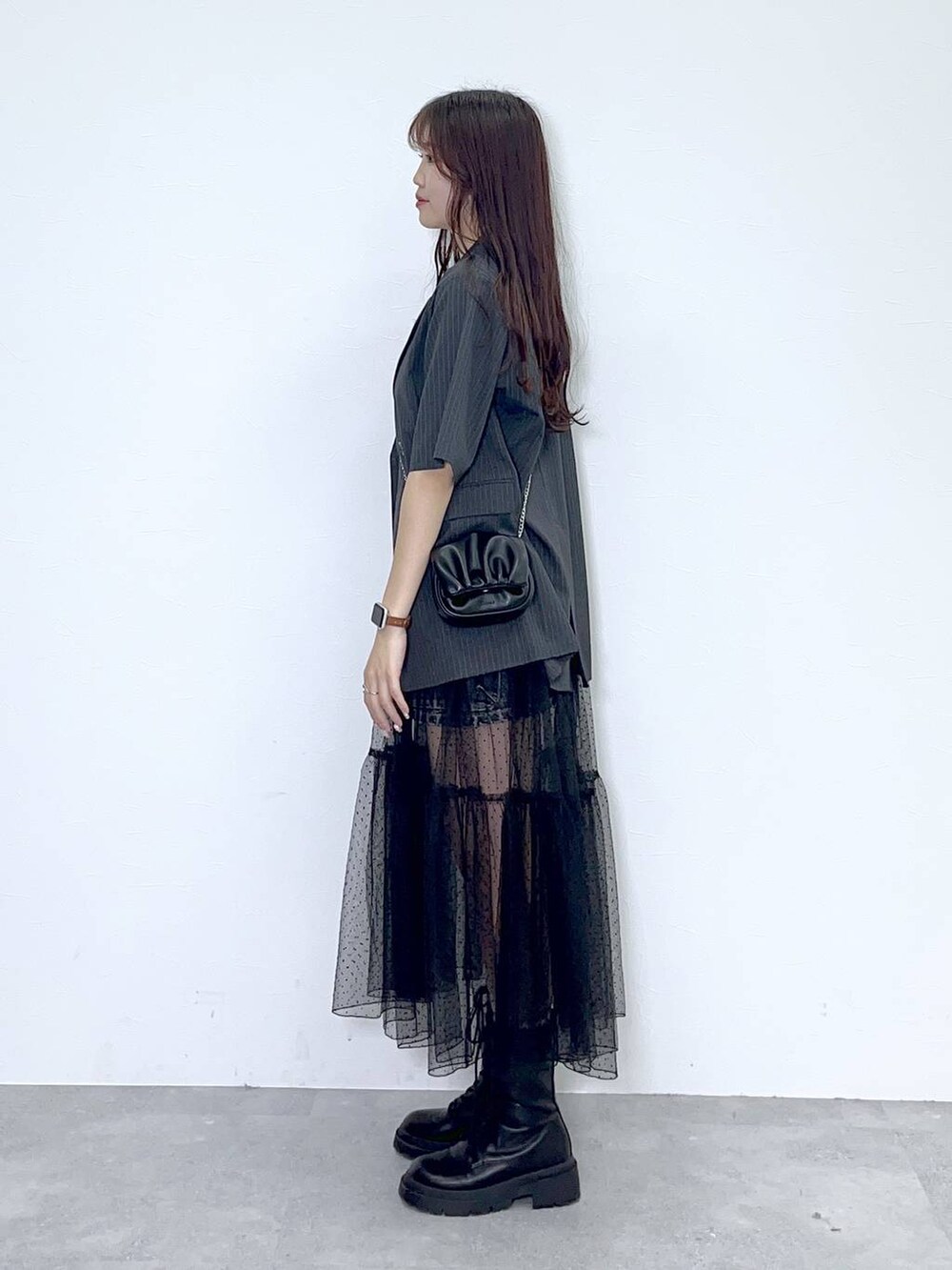 ブラック系のショルダーバッグ、ホワイト系のキャミソール、ブラック系のブーツを着用したレディースの夏コーディネートの4枚目の写真