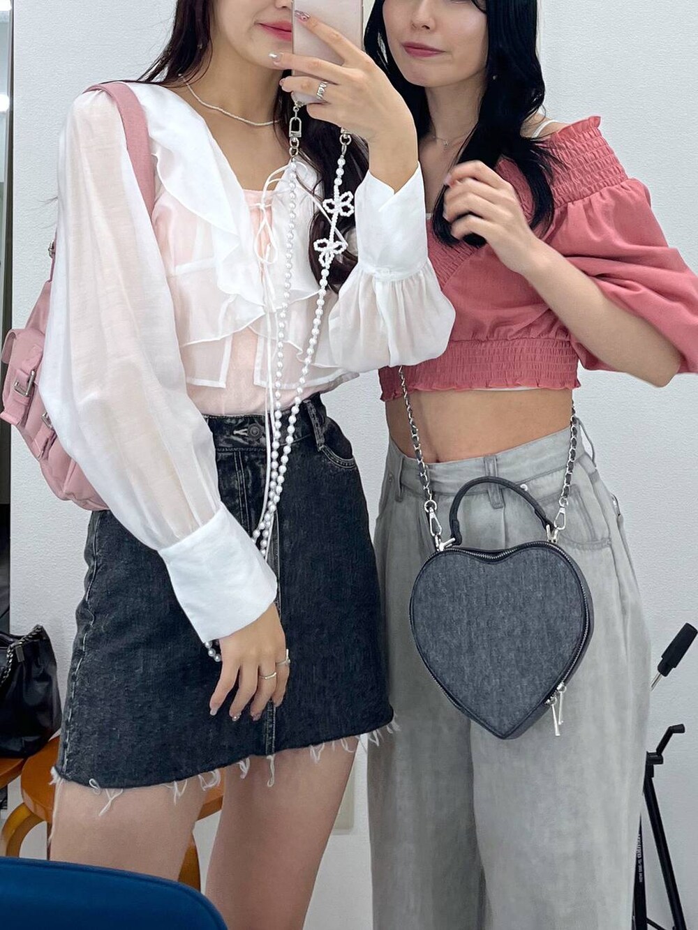 ピンク系のショルダーバッグ、ブラック系のショルダーバッグ、グレー系のデニムパンツを着用したレディースの春コーディネートの3枚目の写真