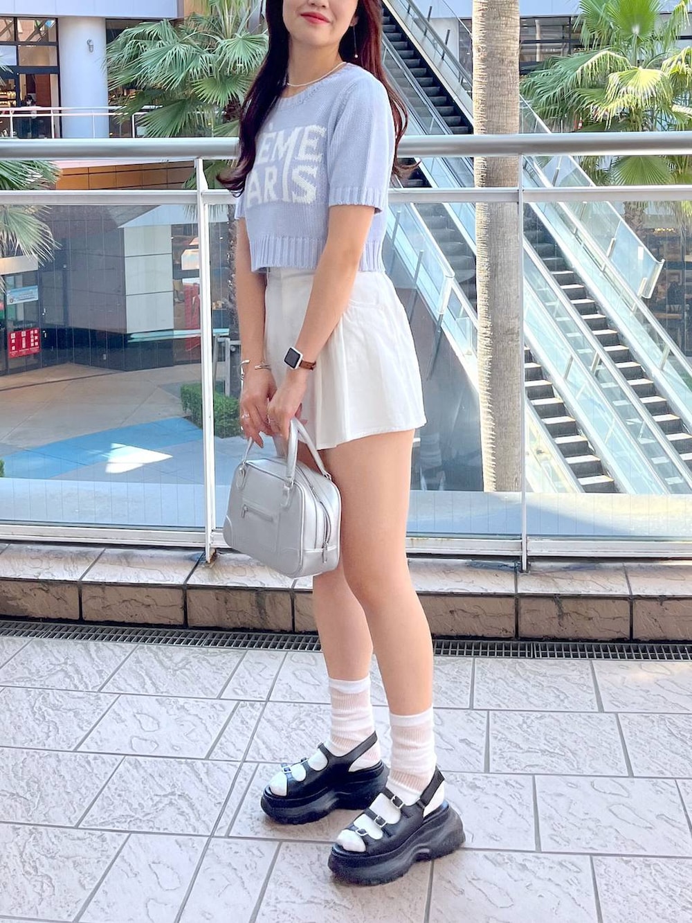 ブルー系のニット/セーター、ホワイト系のキャミソール、ブラック系のサンダルを着用したレディースの夏コーディネートの2枚目の写真