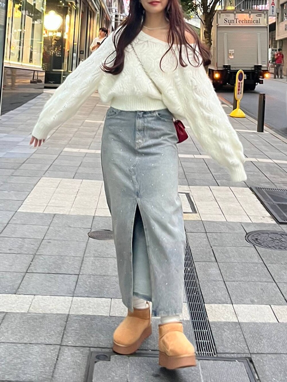 ブルー系のデニムスカート、ホワイト系のキャミソール、レッド系のショルダーバッグを着用したレディースの秋コーディネートの8枚目の写真