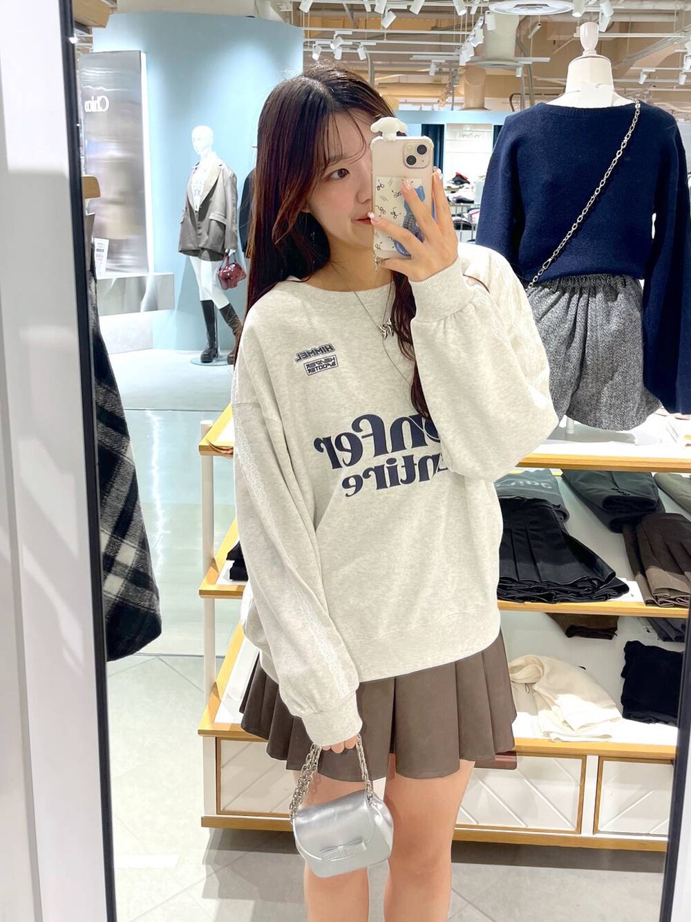 ホワイト系のTシャツ/カットソー、ブラウン系のスカート、ベージュ系のブーツを着用したレディースの秋コーディネートの4枚目の写真