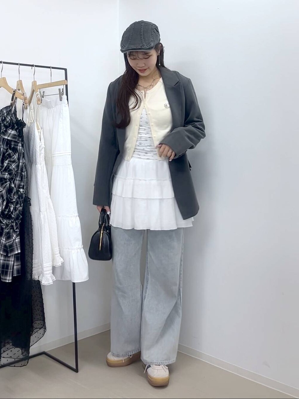 ホワイト系のキャミソール、ブルー系のデニムパンツ、ホワイト系のスカートを着用したレディースの春コーディネートの3枚目の写真